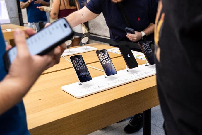 Varias personas ven los nuevo modelos de iPhone en la tienda de Apple de la Puerta del Sol