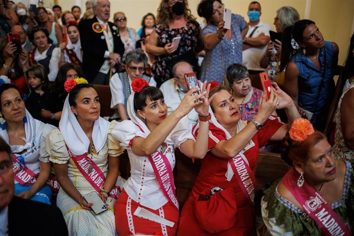 Archivo - Un grupo de mujeres fotografían la solemne bajada anual del cuadro de la Virgen de la Paloma, en la iglesia de La Paloma y San Pedro el Real, a 15 de agosto de 2022, en Madrid (España). 