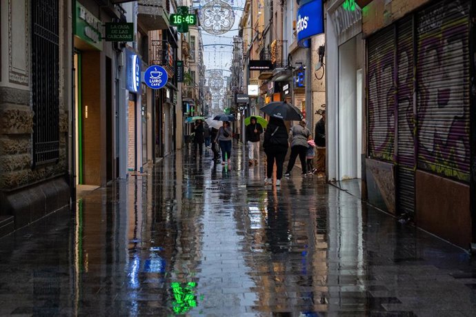Archivo - Varias personas caminan con paraguas, a 20 de diciembre de 2025, en Badalona, Barcelona, Catalunya (España). 