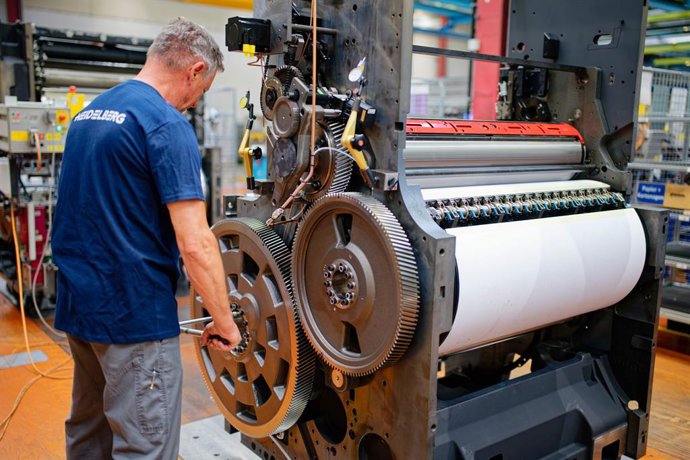 Archivo - Arquivo - ARQUIVADO - 2 de junho de 2025, Baden-Wuerttemberg, Wiesloch: Um funcionário está em frente a uma unidade de impressão Speedmaster CLX 104 em um pavilhão de produção da Heidelberger Druckmaschinen. O setor alemão de engenharia de máqui