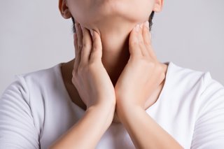 Archivo - Mujer tocándose el cuello.