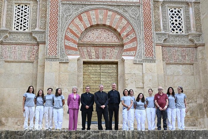 Responsables del Cabildo y el equipo de restauración posan ante la la recuperada Puerta de San Ildefonso en la Mezquita-Catedral de Córdoba.
