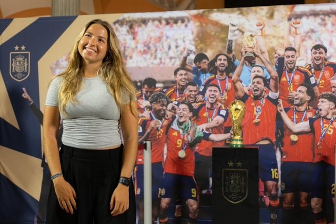 Una visitante en el Ayuntamiento de Sevilla posa junto a la Copa del Mundo