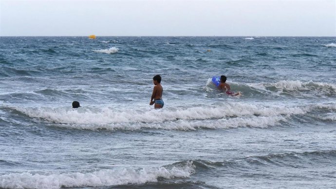 Archivo - Niño bañándose en la playa