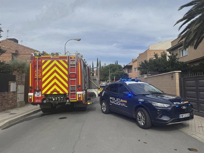 Un camión de Bomberos de la Comunidad de Madrid junto a un coche patrulla de la Policía Nacional atendiendo una emergencia en una casa en Pozuelo de Alarcón