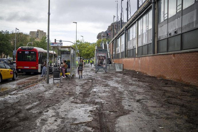 Varias personas pasean por una calle llena de barro por las lluvias, en el barrio de Canyelles-Nou Barris, a 29 de septiembre de 2026, en Barcelona, Catalunya (España). 