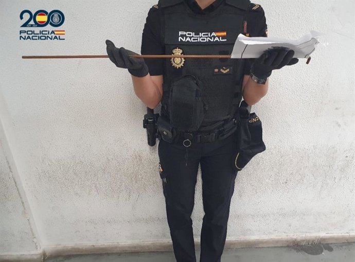 Un agente de la Policía Nacional sostiene la vara de hierro con la que la sospechosa amenazó a otra mujer.