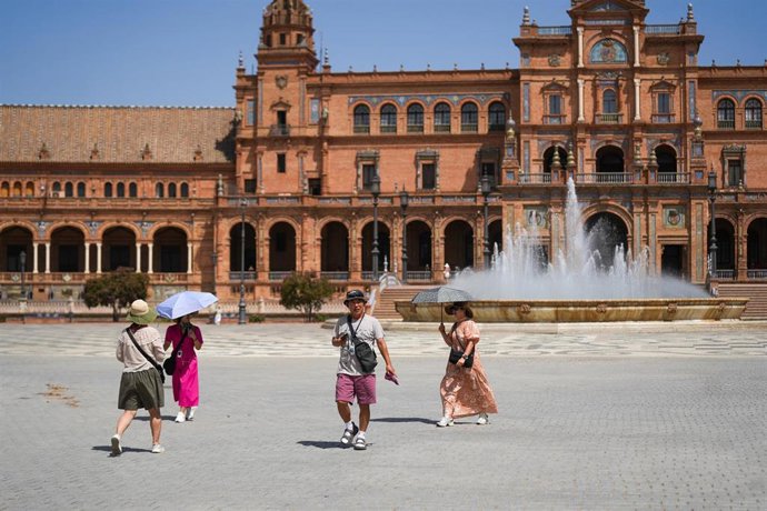 Turistas con sombrillas para protegerse del sol en la Plaza de España. A 03 de septiembre de 2026, en Sevilla (Andalucía, España). 