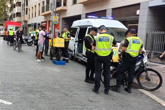 Agentes de la Policía Local de Palma inspeccionan las bicicletas de los repartidores.