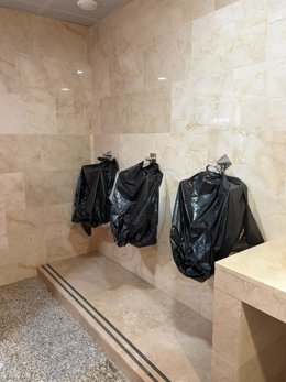 Estado de los urinarios del baño de caballeros, "actualmente fuera de servicio y cubiertos con bolsas de basura", en la estación de AVE de Puente Genil.