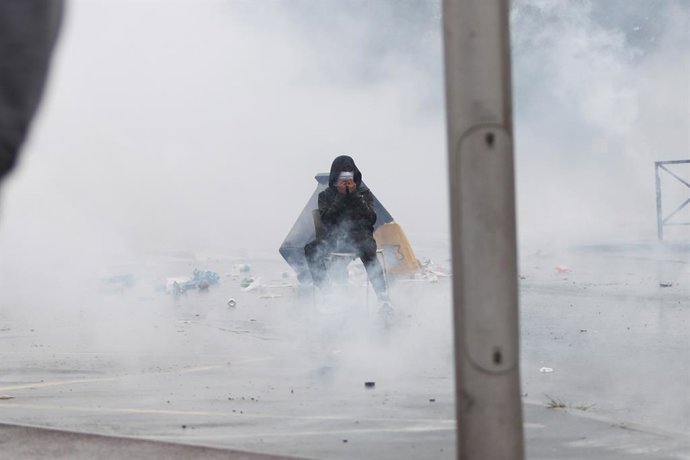 1º de outubro de 2026, França, Anglet: Um jovem manifestante senta-se em uma cadeira e cobre o rosto com as mãos em meio ao gás lacrimogêneo, durante um protesto em frente ao Liceu Cantau, contra as turmas superlotadas e a falta de recursos. O movimento, 