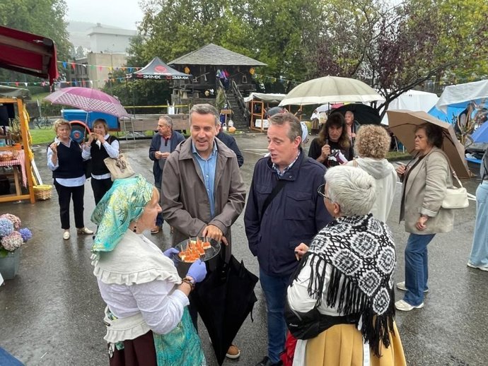 El consejero de Medio Rural y Política Agraria, Marcelino Marcos, y el portavoz del PSOE en Navia, Gonzalo Asenjo, durante su visita al V Mercado Tradicional de Anleo.