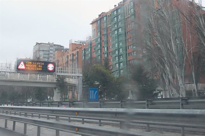 Archivo - Un cartel luminoso en la carretera avisa de la lluvia durante la borrasca ‘Karlotta’, a 9 de febrero de 2024, en Madrid (España).