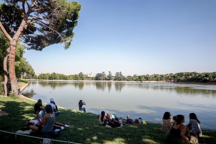 Archivo - Varias personas sentadas en la orilla del lago de la Casa de Campo, a 21 de agosto de 2022, en Madrid (España)