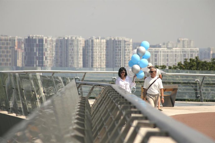 Archivo - Arquivo - 4 de agosto de 2026, Kiev, Ucrânia: Uma mulher com balões e um homem caminham pela ponte para pedestres e ciclistas sobre a Descida Volodymyrskyi, em Kiev, Ucrânia, em 4 de agosto de 2026. A capital ucraniana é o centro político e admi