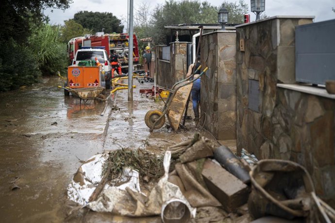 Carrer i vehicles coberts de fang a causa de les pluges torrencials