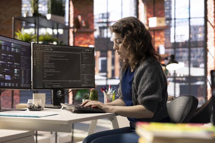 Archivo - Arquivo - Engenheiro de software trabalhando em dois monitores e digitando código para um projeto de desenvolvimento. Desenvolvedor técnico realizando várias tarefas ao mesmo tempo, depurando e utilizando ferramentas digitais avançadas para prog