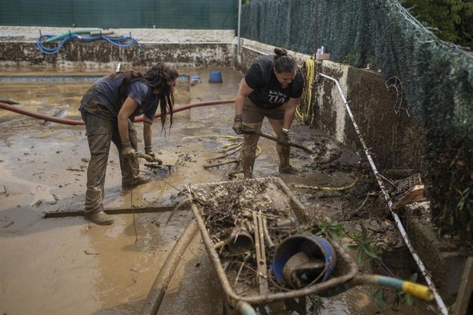 Vecinos limpian el barro acumulado en las calles y casas a causa de las lluvias torrenciales en Montornès del Vallès (Barcelona)