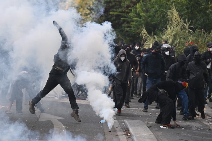 06 October 2026, France, Paris: A demonstrator throws back a tear gas canister during severe clashes with the police at a demonstration against education conditions.