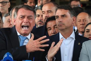 Archivo - El expresidente de Brasil Jair Bolsonaro, observado por su hijo Flávio Bolsonaro, comparece ante la prensa tras la admisión en el Tribunal Supremo de una acusación en su contra por intento de golpe de Estado