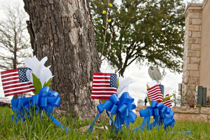 Archivo - Un monumento improvisado con pequeñas banderas junto a la puerta principal de Fort Hood, en Texas.
