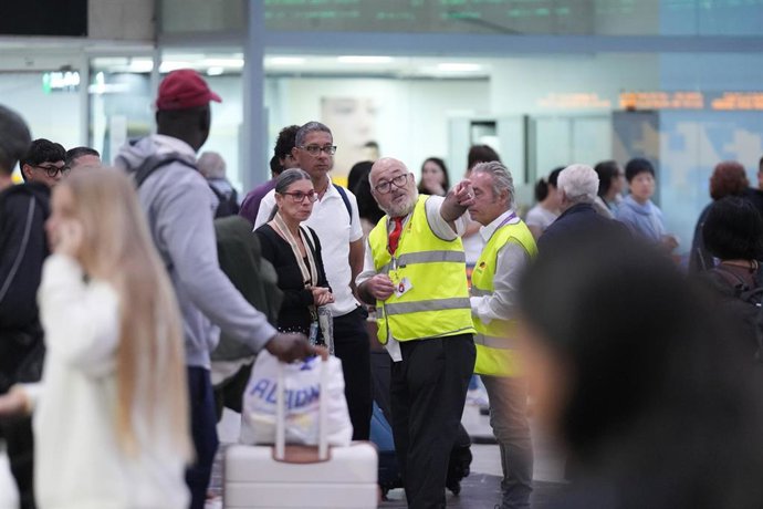 Trabajadores informan a los pasajeros en la estación de Sants.