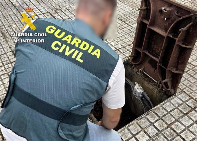 Un agente de la Guardia Civil revisa una arqueta de cableado