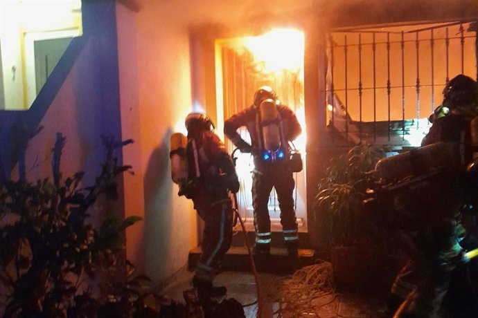 Efectivos del Parque de Bomberos de Cartagena extinguen un incendio en una vivienda dúplex de la calle Diosa Iside, en Playa Honda