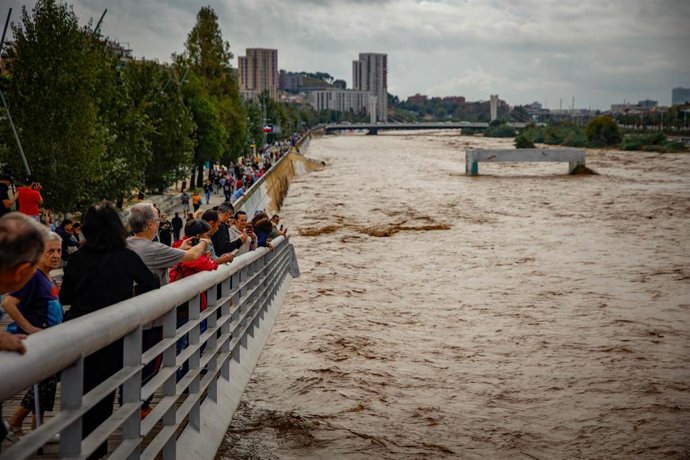 Varias personas observan la crecida del río Besòs a causa de las lluvias torrenciales de la pasada noche, a 4 de octubre de 2026, en Santa Coloma de Gramenet, Barcelona, Catalunya (España). Protecció Civil de la Generalitat ha enviado un Es-Alert a la pob