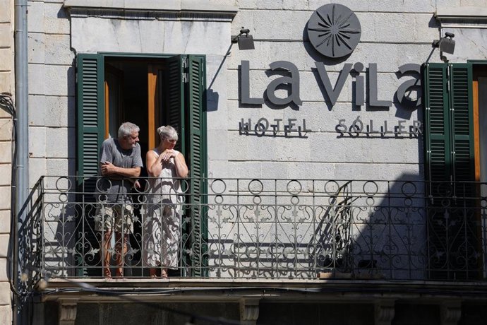 Archivo - Dos personas asomadas al balcón de un hotel durante una manifestación contra la masificación turística, a 8 de agosto de 2026, en Sóller, Mallorca, Islas Baleares (España).