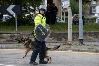 October 3, 2026, Dover, United Kingdom: A member of the police dog unit with her German Shepherd during a demonstration in Dover. Supporters of the English Defence League (EDL) gathered in Dover, UK to march through the town all the way to the harbour. En