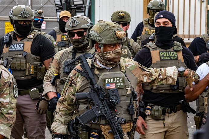 Archivo - Arquivo – 6 de junho de 2026, Newark, Nova Jersey, EUA: Um agente do ICE, armado com um fuzil do tipo M4, está do lado de fora do centro de detenção de imigrantes Delaney Hall, em Newark.