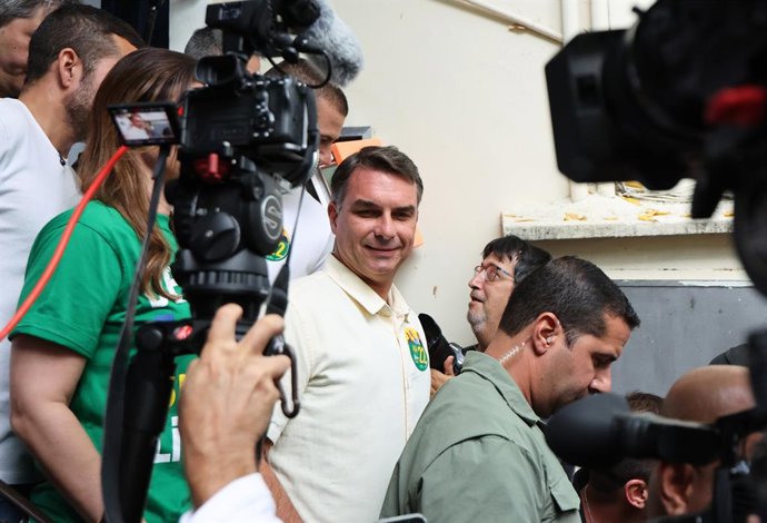 BRASÍLIA, 4 de outubro de 2026  -- Flávio Bolsonaro (C), candidato à presidência pelo Partido Liberal do Brasil, sai após votar em uma seção eleitoral no Rio de Janeiro, Brasil, em 4 de outubro de 2026. A votação no primeiro turno das eleições presidencia
