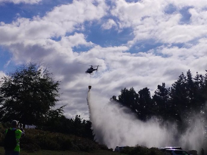 Un helicóptero realizando una descarga de agua