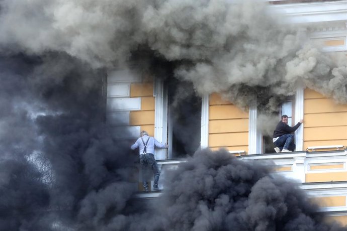 September 28, 2026, Kyiv, Ukraine: Two men attempt to escape from the National Academy of Sciences building, which is engulfed in flames after being hit by a Russian drone, Kyiv, Ukraine, September 28, 2026. One person was killed, and three others were in