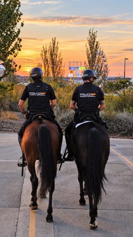 Dos agentes de Seguridad Ciudadana patrullan las calles de Zaragoza, durante las fiestas del Pilar, a caballo.