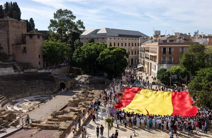 Despliegue de una gran bandera de España en un acto del PP en Málaga por el día de la Fiesta Nacional.