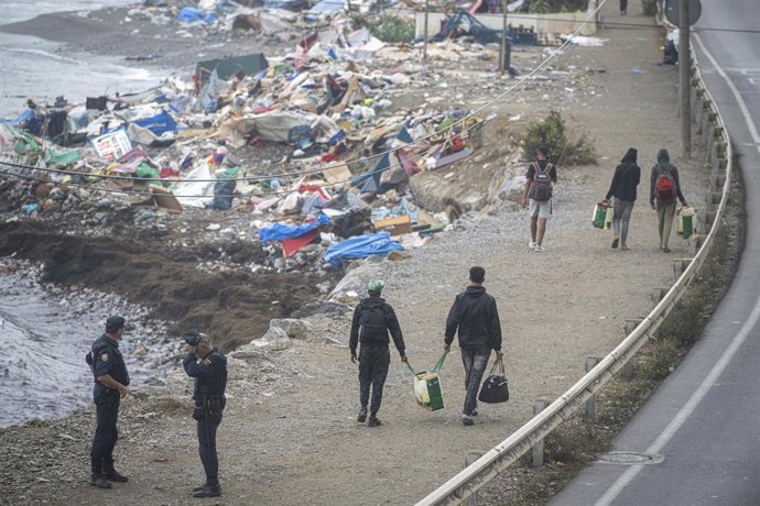 Agentes de la Policía Nacional intervienen durante el proceso de desalojo del embolsamiento de migrantes en la playa de El Trampolín, a 5 de octubre de 2026, en Ceuta (España). 