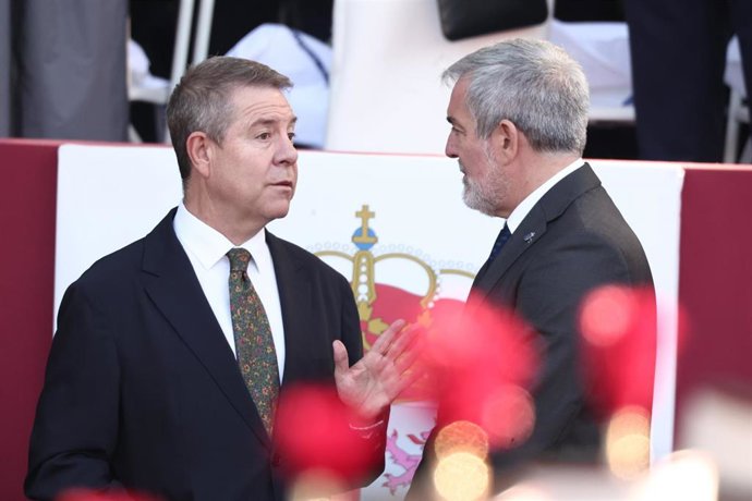 El presidente de Castilla-La Mancha, Emiliano García-Page (i), y el presidente del Gobierno de Aragón, Jorge Azcón (d), durante el acto solemne de homenaje a la bandera nacional y desfile militar por el 12 de octubre.