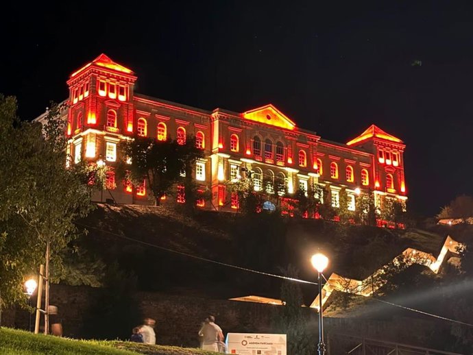 Fachada de la Diputación iluminada con la bandera de España.