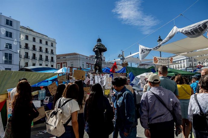 Varias personas observan los mensajes, en la Puerta del Sol, a 10 de octubre de 2026, en Madrid (España). El consejero de Vivienda, Transporte e Infraestructuras de la Comunidad de Madrid, Jorge Rodrigo, ha asegurado este sábado que la acampada instalada 