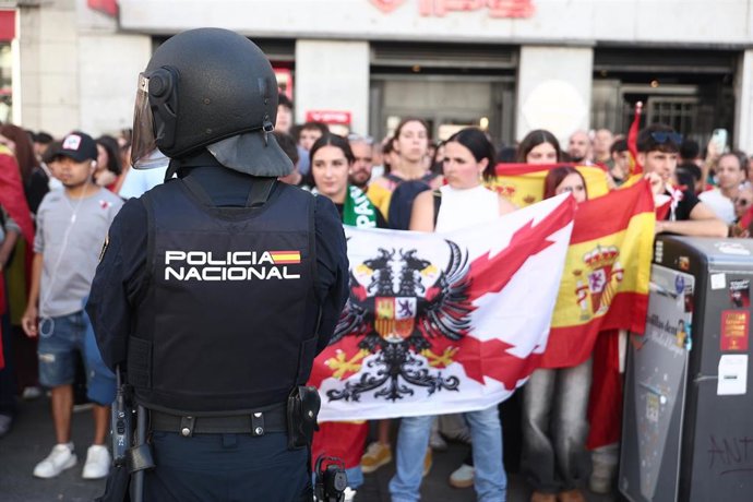 Varias personas con la bandera de España increpan a los acampados por la vivienda en la Puerta del Sol