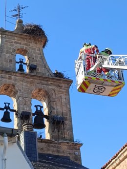 Los bomberos retiran un nido de cigüeña con riesgo de caída de un campanario de Reinosa