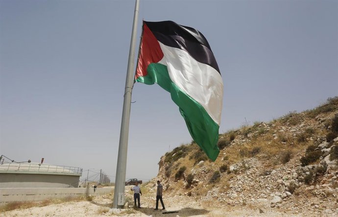 Archivo - Palestinos despliegan una gran bandera de Palestina durante una protesta en la ciudad de Nablus, en Cisjordania