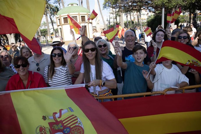 Melillenses con banderas españolas esperan la llegada de los Reyes en la Plaza de España de la ciudad autónoma
