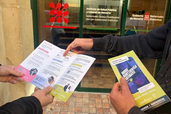 Dos personas leen el folleto de ‘Pantallas y salud emocional’, que ha elaborado el servicio de Promoción de Salud Comunitaria del ISPLN/NOPLOI en castellano y en euskera.