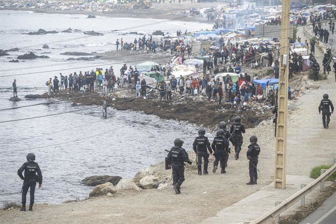 Agentes de la Policía Nacional intervienen durante el proceso de desalojo del embolsamiento de migrantes en la playa de El Trampolín, a 4 de octubre de 2026, en Ceuta (España). 