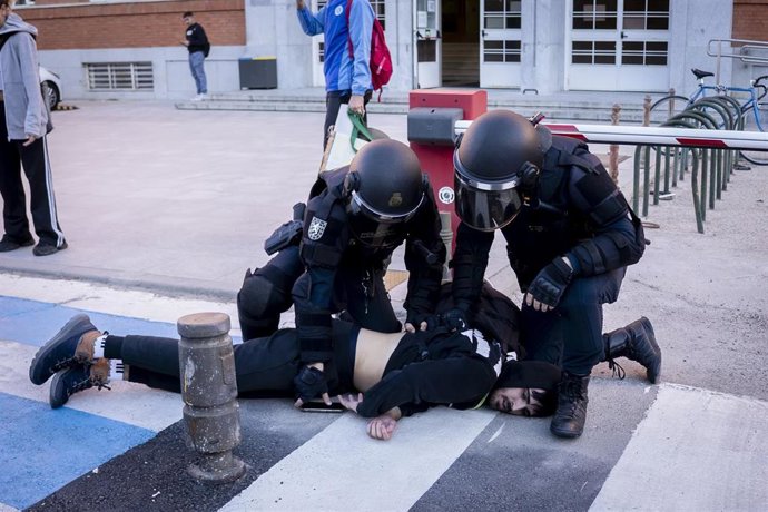 Dos policías inmovilizan a un estudiante  