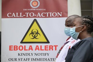 NAIROBI, Oct. 7, 2026  -- Medical workers walk past an Ebola alert poster at Nairobi Hospital in Nairobi, Kenya, Oct. 7, 2026. Kenya on Tuesday confirmed its first imported case of Bundibugyo Ebola virus disease, one day after a man died in a Nairobi hosp