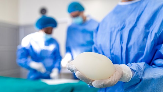 Archivo - Cirujano sujetando implante mamario de silicona en quirófano. Primer plano de un médico preparándose para la cirugía de aumento de pecho. Concepto de sanidad y medicina. Especialista en cirugía plástica.